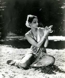 A black and white photograph of Madame Menaka sitting on a lawn.