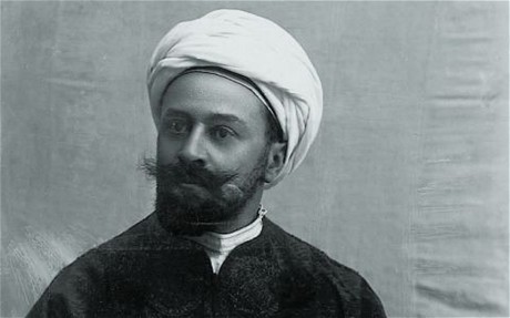 The picture is a photo portrait of Max Freiherr von Oppenheim, who was wearing a white headdress akin to a turban and a dark beard with a bushy moustache.