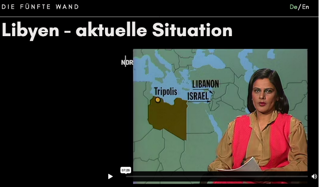 Das Bild zeigt einen Screenshot aus "Die Fünfte Wand". Eine Überschrift lautet "Libyen -aktuelle Situation" darunter Navina Sundaram, wie sie einen Bericht während einer Nachrichtensendung im Fernsehen vorträgt.