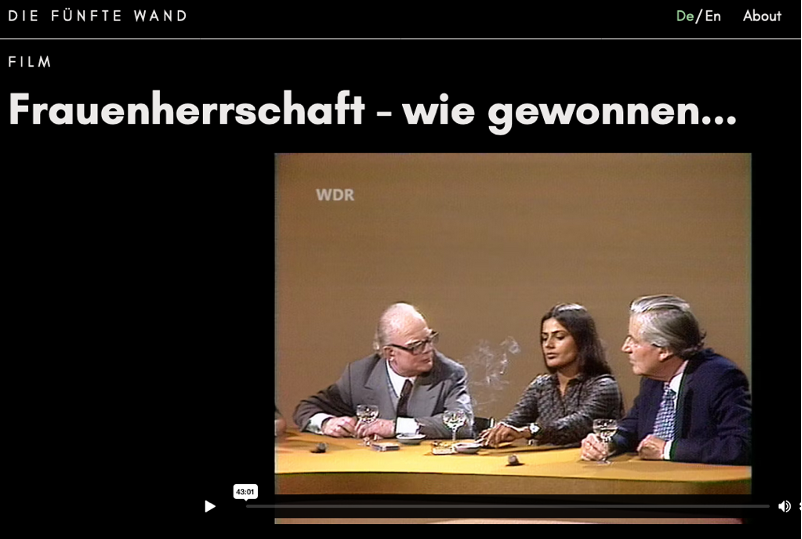 Ein Screenshot aus "Die Fünfte Wand" mit der Überschrift "Frauenherrschaft - wie gewonnen..." Darunter ein Einzelbild aus dem "Internationalen Frühschoppen. Sundaram sitzt mittig zwischen zwei älteren Herren und raucht eine Zigarette; alle drei trinken Wein.